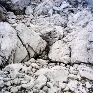 Field of pale, broken boulders and scree on a steep mountainside